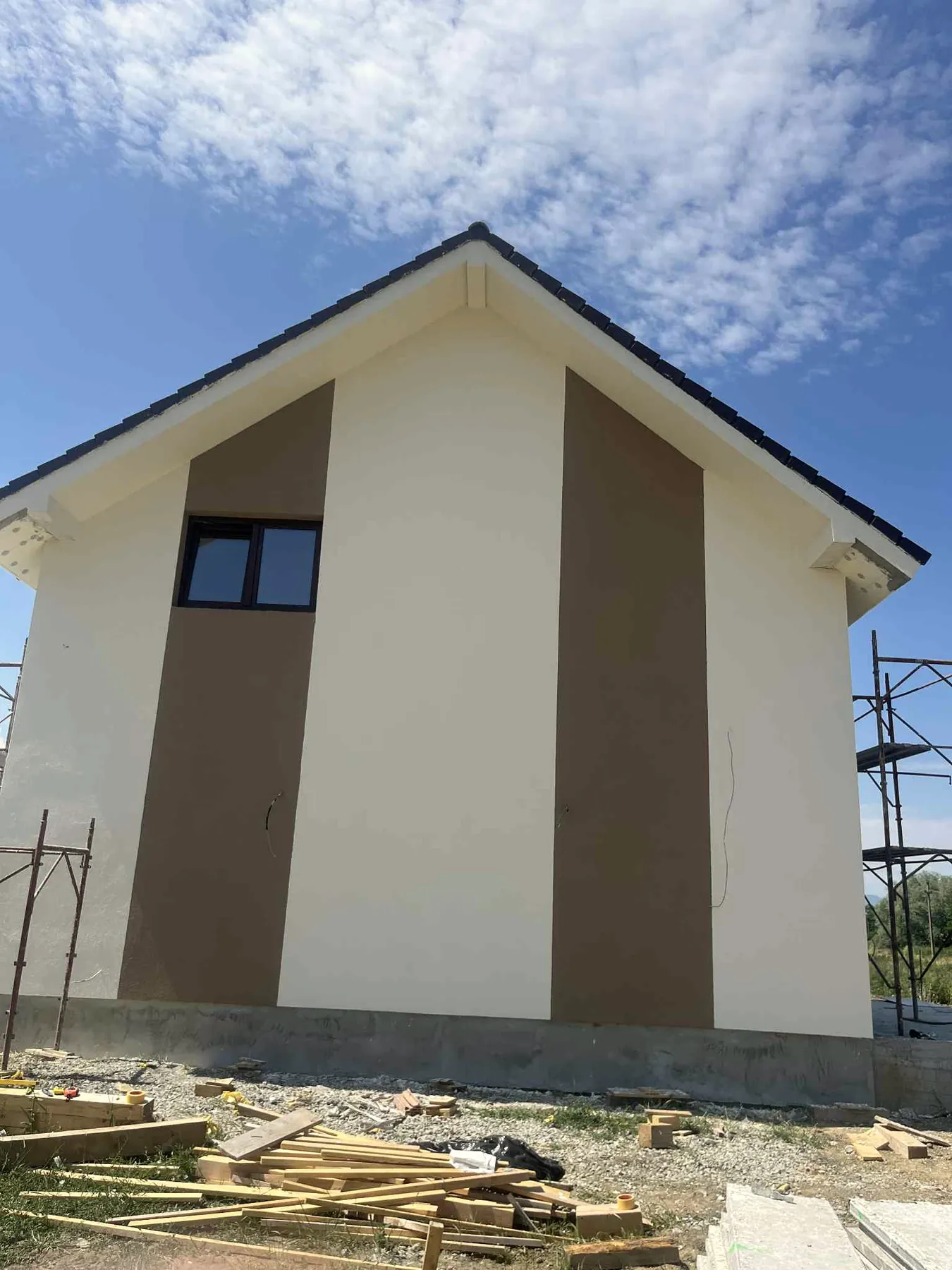 Casă cu termosistem și tencuială decorativă crem cu benzi maro